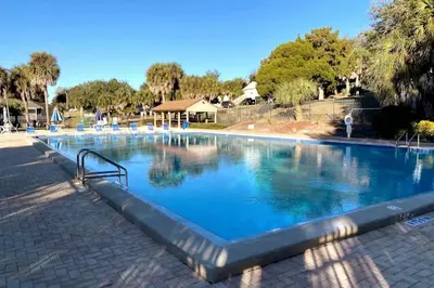 a large swimming pool with blue water at Cottage-pvt Lake & Pool Access Near Disney Wporch in Clermont