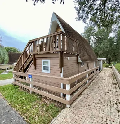 a large house with a deck on the side of it at Lilac Loft- Lake, Pool, Pickle Ball, Disney, Fun! in Clermont