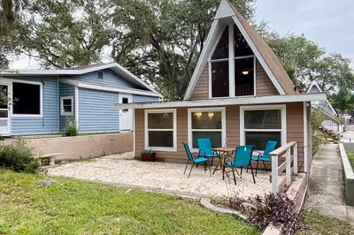 a small blue house with a table and chairs at Lilac Loft- Lake, Pool, Pickle Ball, Disney, Fun! in Clermont