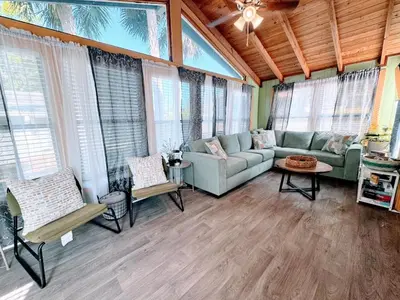 a living room with a couch and chairs and windows at Pumba's Place - Fun, Lake, Pool- No Cleaning Fees! in Clermont