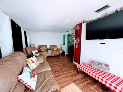 a living room with couches and a flat screen tv at Stay The Enchanted Escape ! in Clermont