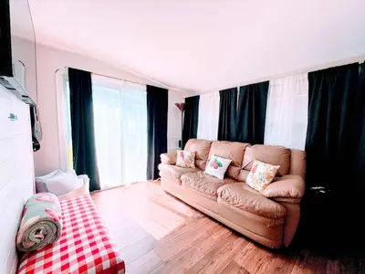 a living room with a brown leather couch and windows at Stay The Enchanted Escape ! in Clermont