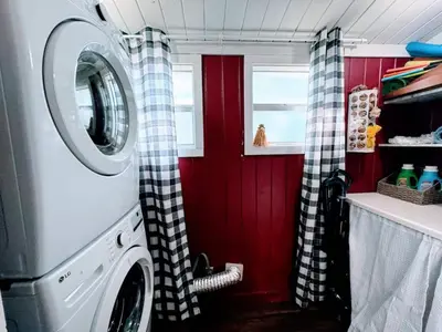 a washing machine in a kitchen with red walls at Stay The Enchanted Escape ! in Clermont