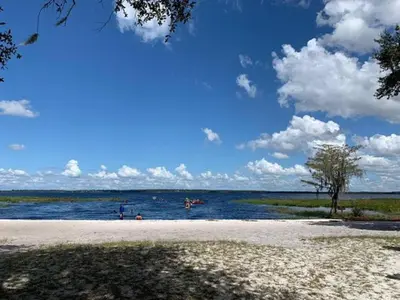 a beach with people swimming in the water at Stay The Enchanted Escape ! in Clermont