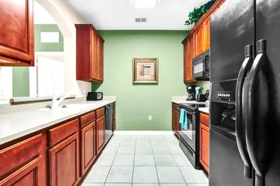 a kitchen with black appliances and green walls at LOCATION - Clubhouse & Pool in Orlando
