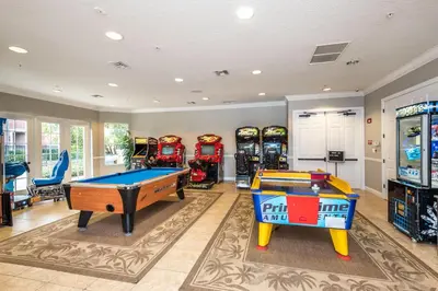 a game room with two pool tables and slot machines at LOCATION - Clubhouse & Pool in Orlando