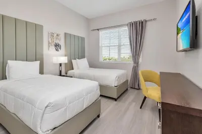 a hotel room with two beds and a desk at WOW New Upscale Penthouse in Orlando