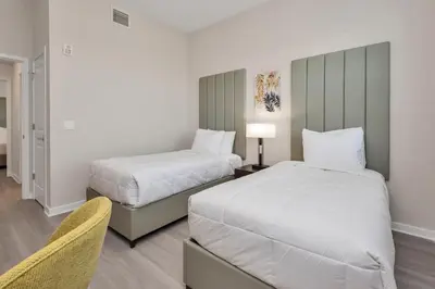 a hotel room with two beds and a chair at WOW New Upscale Penthouse in Orlando