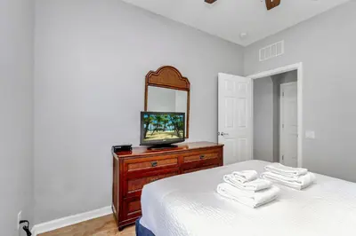 a bedroom with a bed with a television on a dresser at Conservation View Updated WOW in Orlando