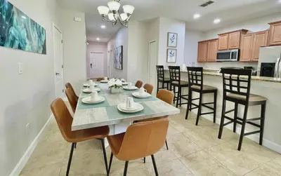a dining room and kitchen with a table and chairs at Cheerful 5 Bdr Sunny Pool in Kissimmee