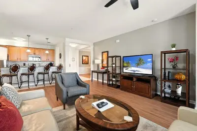 a living room with a couch a table and a kitchen at Direct Lake Front View Luxury in Orlando