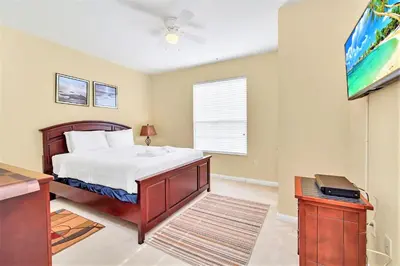 a bedroom with a bed and a flat screen tv at WOW Huge Stunner Corner in Orlando