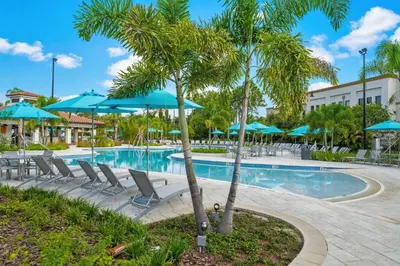 a pool at a resort with chairs and umbrellas at Lake Front huge by clubhouse in Orlando