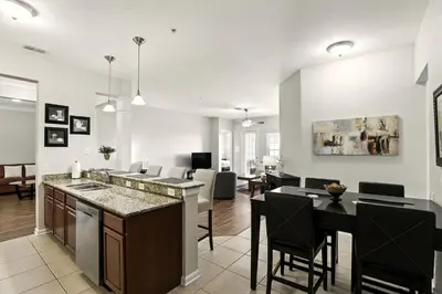 a kitchen and living room with a table and chairs at WOW Upscale Penthouse in Orlando