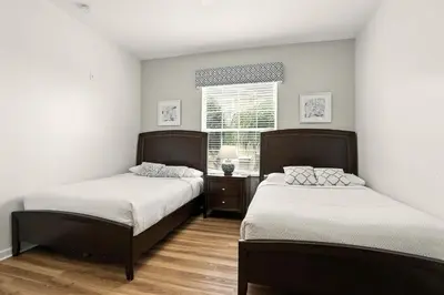 two beds in a small room with a window at Huge Stunning Corner Home 304 in Orlando