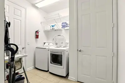 a kitchen with a washing machine and a white door at Huge Stunning Corner Home 304 in Orlando