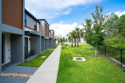 a walkway next to a building with a yard at Luxury Town House Near Disney in Kissimmee