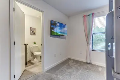 a bathroom with a toilet and a window at Luxury Town House Near Disney in Kissimmee