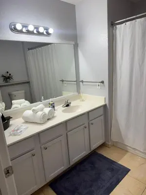 a bathroom with a sink and a large mirror at Luxury house in Disney in Kissimmee