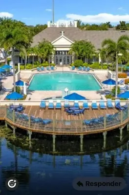 a pool with chairs and umbrellas in front of a resort at Luxury house in Disney in Kissimmee