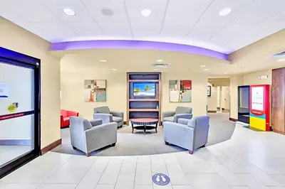 a waiting room at a hospital with chairs and tables at Stylish King Apt w Arcade Game & BBQ Near Disney in Orlando