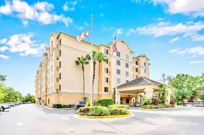 a hotel with a flag on top of it at Stylish King Apt w Arcade Game & BBQ Near Disney in Orlando