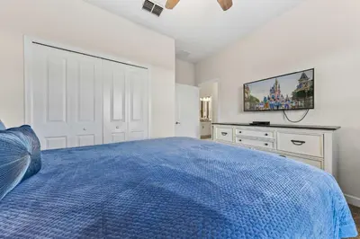 a bedroom with a blue bed and a tv at Gorgeous 5Bd w Pool & Lazy River at Storey Lake 4989 in Kissimmee