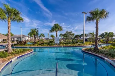 a swimming pool with palm trees in a resort at 5 Bedrooms 4 Bathrooms Storey Lake 4984Wa in Kissimmee