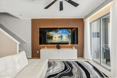 a living room with a white couch and a tv at 5 Bedrooms 4 Bathrooms Storey Lake 4984Wa in Kissimmee