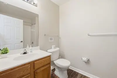 a bathroom with a toilet and a sink and a mirror at Disney 8mi Heated Resort Pool Hot Tub Fitness in Kissimmee