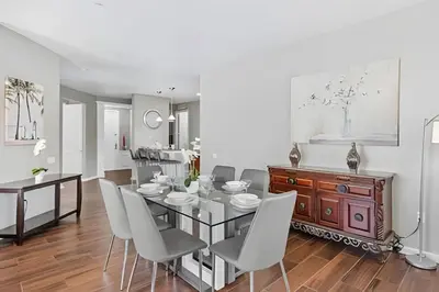 a dining room with a glass table and white chairs at Vista Cay: 4Q c/ Varanda e Mesa de Pebolim in Orlando