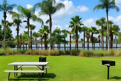 a picnic table in a park with palm trees at Vista Cay: 4Q c/ Varanda e Mesa de Pebolim in Orlando