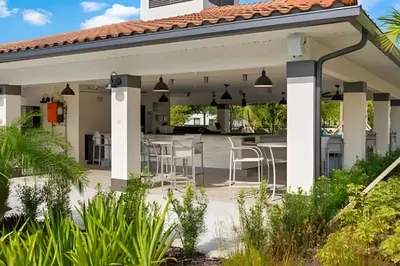 an outdoor patio with a pavilion with bar stools at Vista Cay: 4Q c/ Varanda e Mesa de Pebolim in Orlando