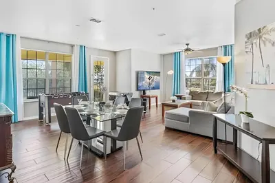 a dining room and living room with a table and chairs at Vista Cay: 4Q c/ Varanda e Mesa de Pebolim in Orlando
