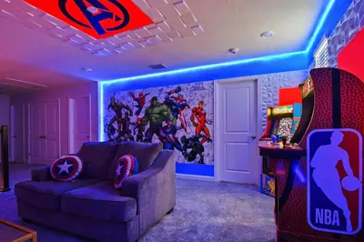 a gaming room with a couch and a video game at 9 MI to Disney w Pool Cinema & FREE Waterpark in Kissimmee