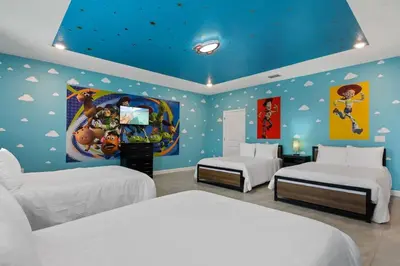 a bedroom with two beds and a blue wall at 9 MI to Disney w Pool Cinema & FREE Waterpark in Kissimmee