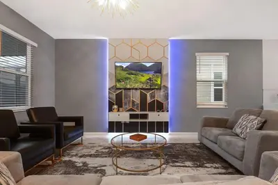 a living room with a couch and a tv at 9 MI to Disney w Pool Cinema & FREE Waterpark in Kissimmee