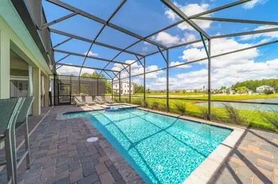 a swimming pool in a house with a glass ceiling at Themed 9BR Retreat Pool & Soccer Fun in Kissimmee