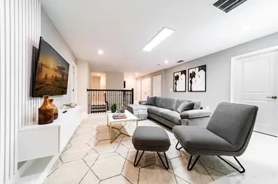a living room with a couch and a table at Themed 9BR Retreat Pool & Soccer Fun in Kissimmee