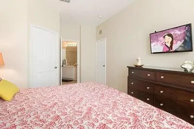 a bedroom with a bed and a tv on a wall at Condo 3Q Windsor Hills — Perto da Disney in Orlando