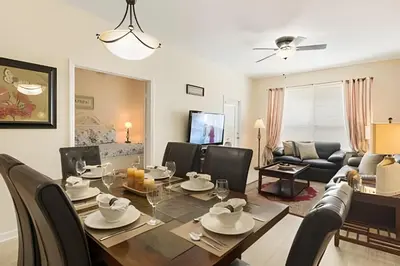 a dining room and living room with a table and chairs at Condo 3Q Windsor Hills — Perto da Disney in Orlando