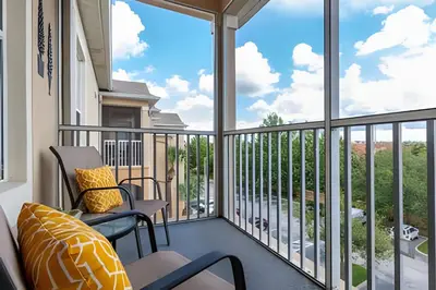 a balcony with two chairs and a large window at Condo 3Q Windsor Hills — Perto da Disney in Orlando