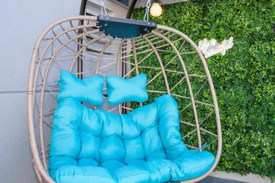 a blue chair sitting in a wicker swing at Studio with Private Terrace and Volcano Bay View Near Epic Universe in Orlando