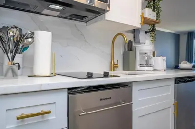 a kitchen with white cabinets and a sink at Studio with Private Terrace and Volcano Bay View Near Epic Universe in Orlando