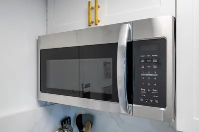 a microwave oven hanging on a kitchen wall at Studio with Private Terrace and Volcano Bay View Near Epic Universe in Orlando
