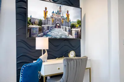 a room with a desk with a picture of the disney castle at Studio with Private Terrace and Volcano Bay View Near Epic Universe in Orlando