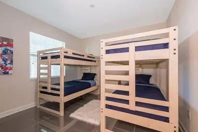 two bunk beds in a room with a bedroom at Spacious Villa w Pool Slides and Lush Nature Views in Kissimmee