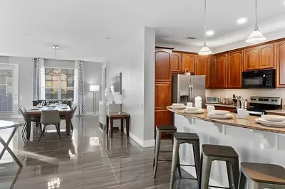 a kitchen and dining room with wooden cabinets at Townhouse Moderna 4Q — Perto da Universal in Orlando