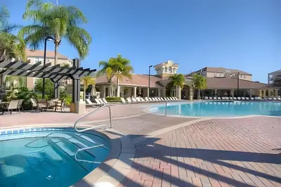 a swimming pool at a resort with palm trees at Townhouse Moderna 4Q — Perto da Universal in Orlando