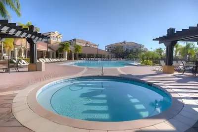 a large pool in a resort with tables and chairs at Townhouse Moderna 4Q — Perto da Universal in Orlando